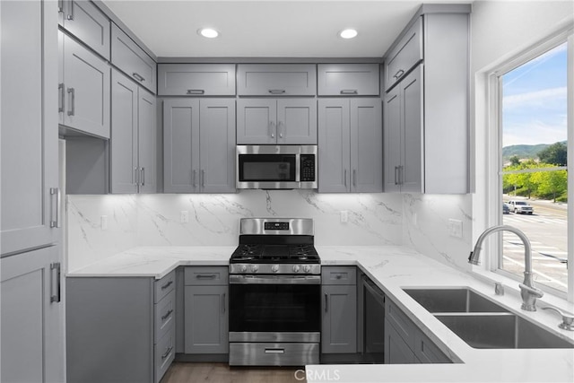 17979 Lost Canyon Rd Unit 104, Canyon Country, CA 91387 - kitchen featuring stainless steel appliances, gray cabinetry, a sink, light stone countertops, and recessed lighting