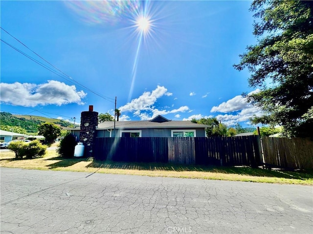 view of side of property featuring fence and a chimney