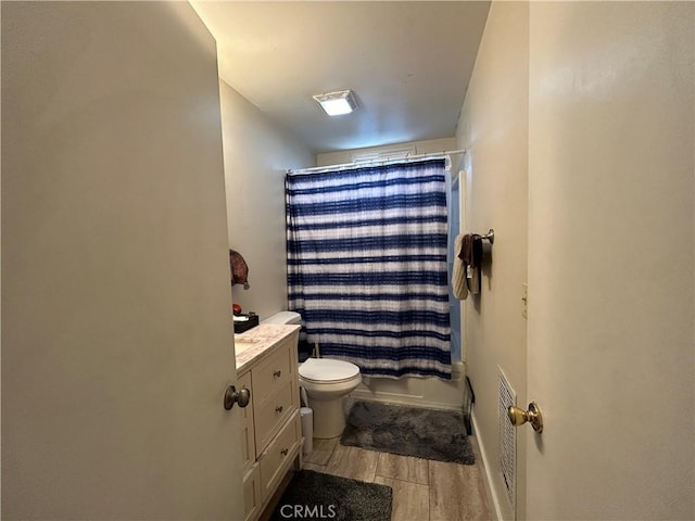 full bathroom featuring wood finished floors, baseboards, toilet, vanity, and shower / bath combo