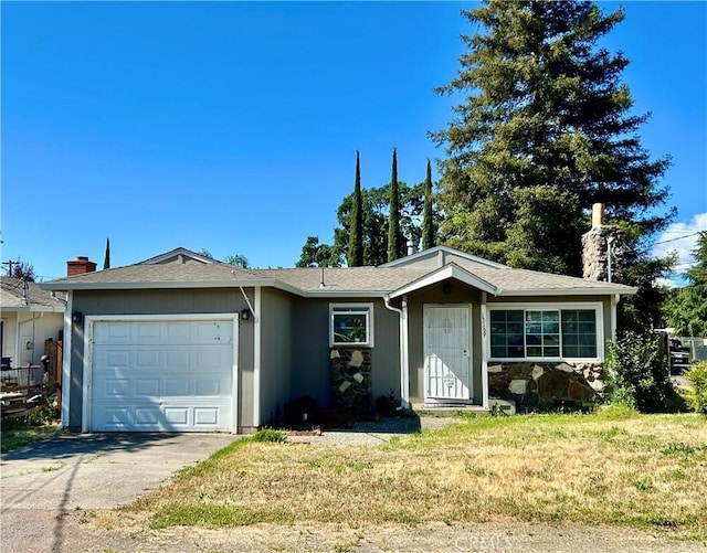 ranch-style house featuring a garage, concrete driveway, and a front yard