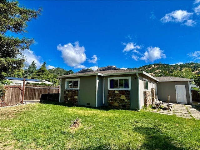 rear view of property with a mountain view, stone siding, and stucco siding