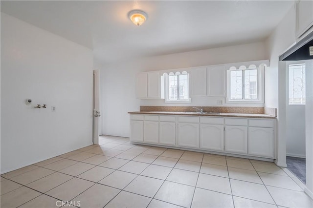 144 W 101st St, Los Angeles, CA 90003 - kitchen featuring white cabinetry, a sink, and light tile patterned floors
