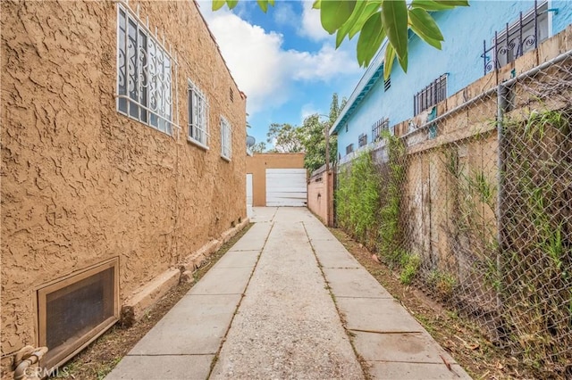 144 W 101st St, Los Angeles, CA 90003 - view of side of property with stucco siding, fence, and a garage