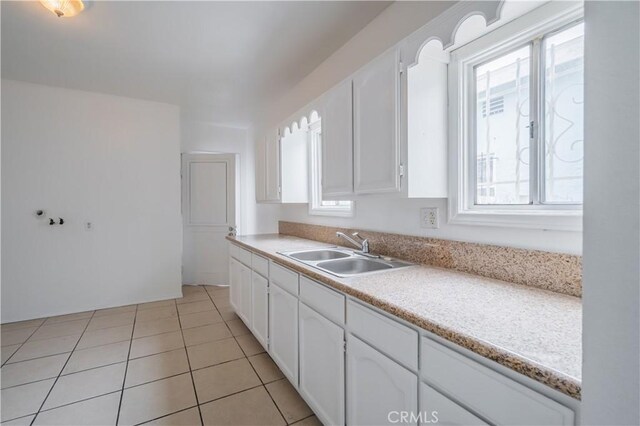 144 W 101st St, Los Angeles, CA 90003 - kitchen featuring a sink, white cabinetry, light tile patterned flooring, and light countertops