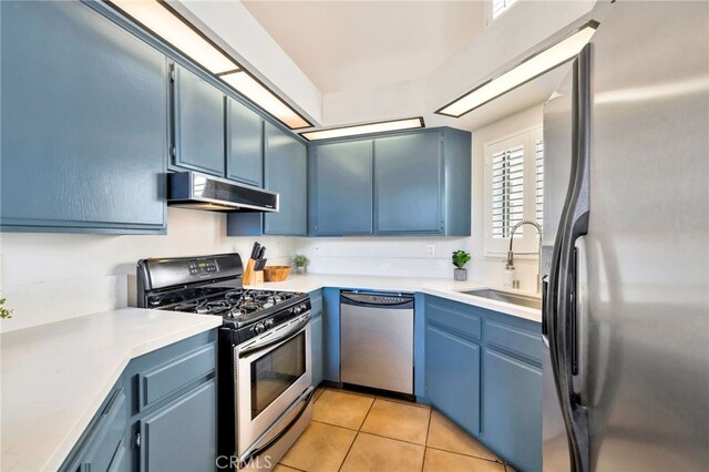 5145 Tortuga Dr Unit 209, Huntington Beach, CA 92649 - kitchen with appliances with stainless steel finishes, light tile patterned floors, light countertops, blue cabinets, and extractor fan