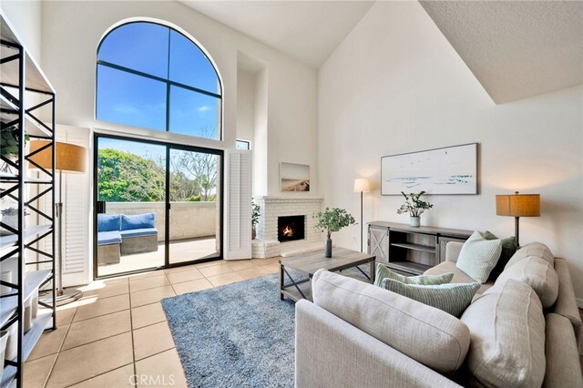 5145 Tortuga Dr Unit 209, Huntington Beach, CA 92649 - living area with high vaulted ceiling, tile patterned flooring, and a brick fireplace