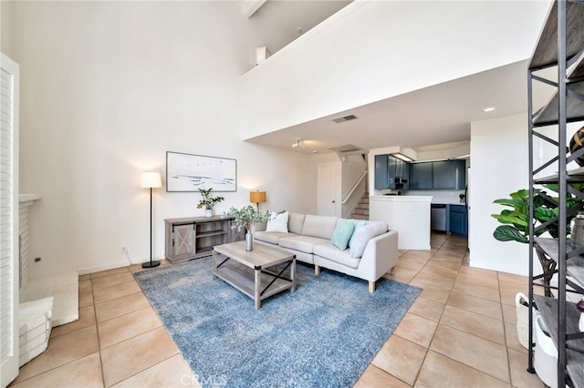 5145 Tortuga Dr Unit 209, Huntington Beach, CA 92649 - living area featuring light tile patterned flooring, stairs, and a towering ceiling
