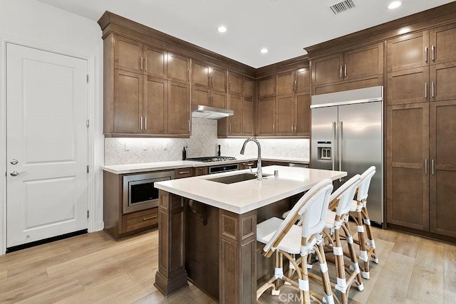 20702 W Chestnut Cir, Porter Ranch, CA 91326 - kitchen with built in appliances, light wood-type flooring, light countertops, a sink, and recessed lighting