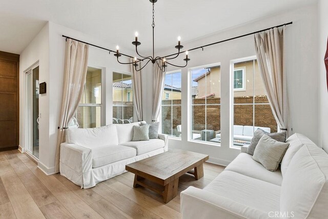 20702 W Chestnut Cir, Porter Ranch, CA 91326 - living room featuring a chandelier, light wood finished floors, and baseboards