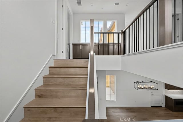 20702 W Chestnut Cir, Porter Ranch, CA 91326 - stairs featuring a chandelier, wood finished floors, and baseboards