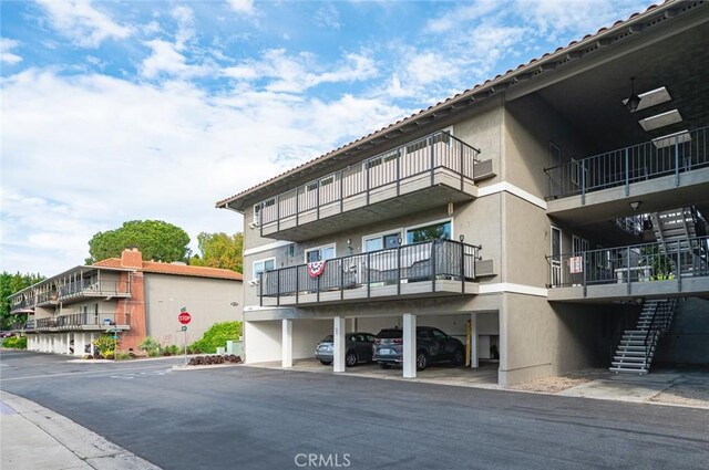 2134 Via Puerta Unit O, Laguna Woods, CA 92637 - view of apartment building / complex with covered parking and stairs