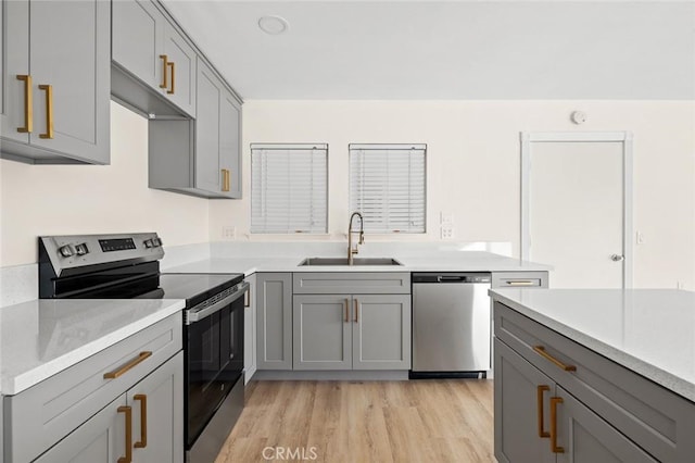 2134 Via Puerta Unit O, Laguna Woods, CA 92637 - kitchen featuring stainless steel appliances, gray cabinetry, a sink, light wood-style floors, and light countertops