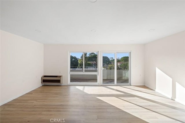 2134 Via Puerta Unit O, Laguna Woods, CA 92637 - unfurnished room with heating unit, wood finished floors, and baseboards