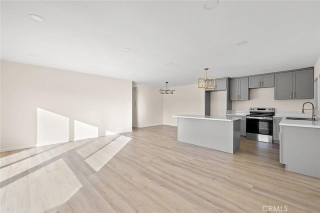 2134 Via Puerta Unit O, Laguna Woods, CA 92637 - kitchen with stainless steel electric range oven, a chandelier, light countertops, light wood-style flooring, and a sink