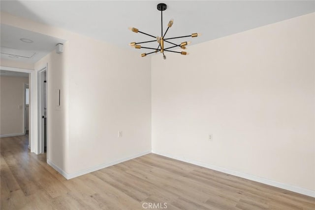 2134 Via Puerta Unit O, Laguna Woods, CA 92637 - unfurnished room with light wood-style floors, a chandelier, and baseboards
