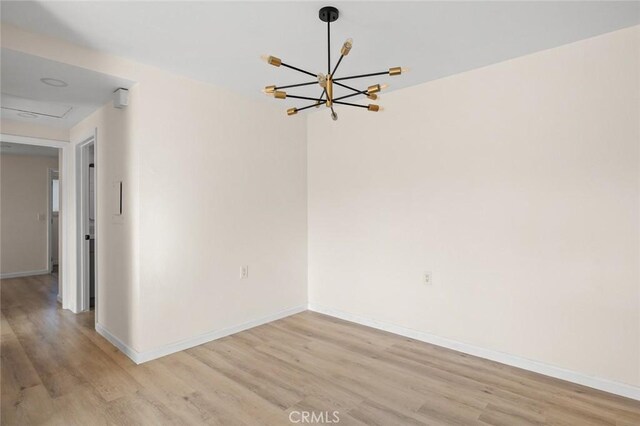 2134 Via Puerta Unit O, Laguna Woods, CA 92637 - unfurnished room featuring light wood-type flooring, a chandelier, and baseboards