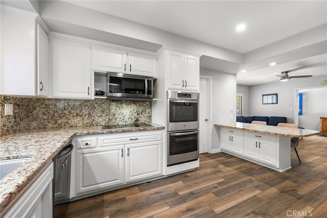 8204 Clemens Ave, West Hills, CA 91304 - kitchen featuring appliances with stainless steel finishes, recessed lighting, a peninsula, dark wood finished floors, and white cabinets