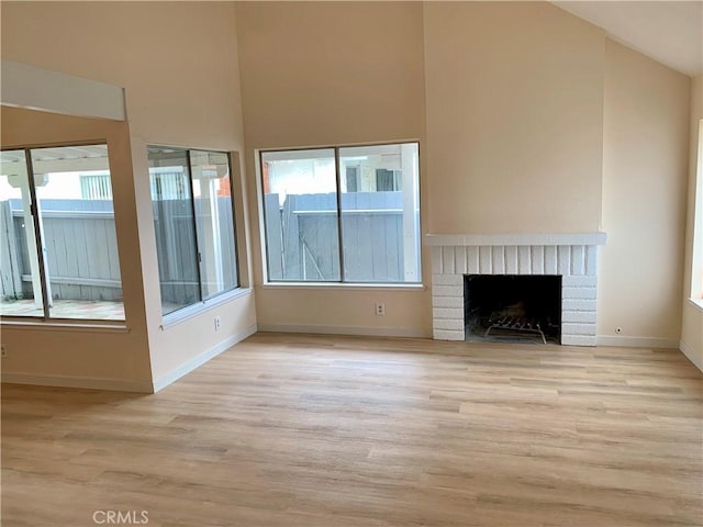 8818 Keremeos Way, San Diego, CA 92126 - unfurnished living room featuring wood finished floors, healthy amount of natural light, high vaulted ceiling, a fireplace, and baseboards