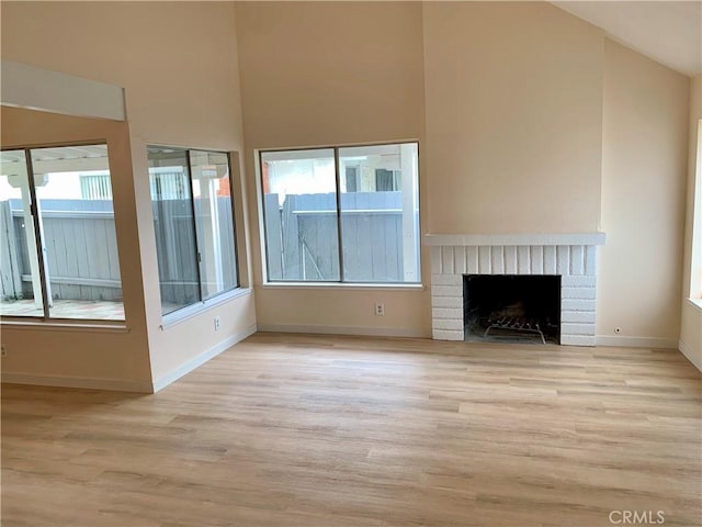 8818 Keremeos Way, San Diego, CA 92126 - unfurnished living room featuring wood finished floors, plenty of natural light, high vaulted ceiling, and a brick fireplace