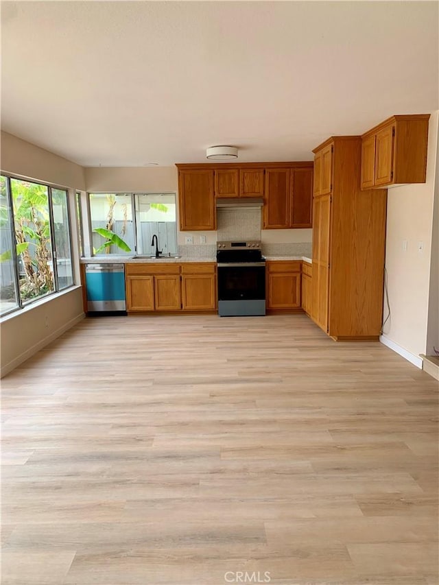 8818 Keremeos Way, San Diego, CA 92126 - kitchen with stainless steel appliances, light countertops, brown cabinetry, baseboards, and light wood-style floors
