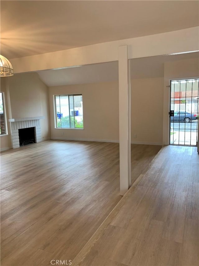 8818 Keremeos Way, San Diego, CA 92126 - unfurnished living room featuring light wood-style floors, a brick fireplace, baseboards, and lofted ceiling