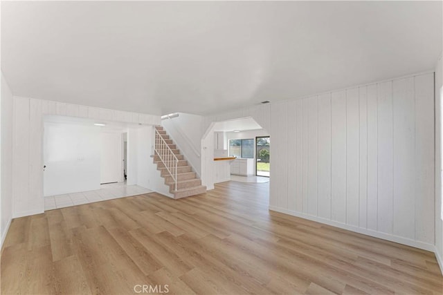 942 E Denwall Dr, Carson, CA 90746 - unfurnished living room with stairs, light wood-style floors, and arched walkways