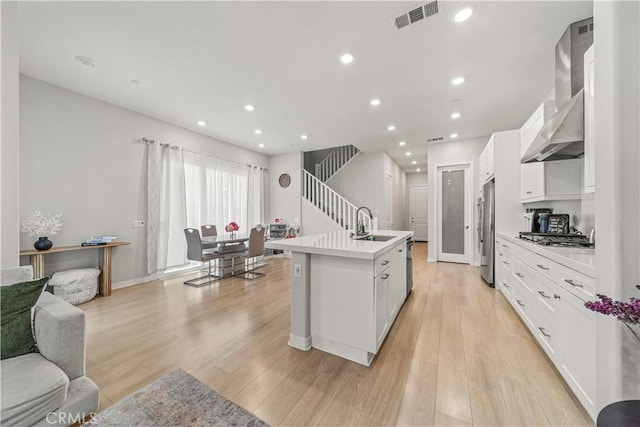 27218 Narrowleaf Willow Ln, Valencia, CA 91381 - kitchen with stainless steel appliances, wall chimney exhaust hood, white cabinetry, light countertops, and recessed lighting