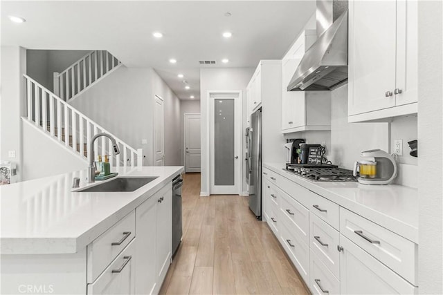 27218 Narrowleaf Willow Ln, Valencia, CA 91381 - kitchen with wall chimney exhaust hood, a sink, light wood-type flooring, white cabinetry, and recessed lighting