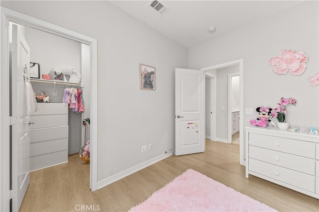 27218 Narrowleaf Willow Ln, Valencia, CA 91381 - bedroom with light wood-type flooring, a spacious closet, baseboards, and a closet