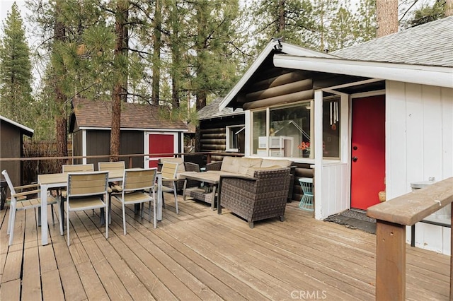 921 Anita Ave, Big Bear City, CA 92314 - wooden terrace featuring outdoor dining space, outdoor lounge area, a storage shed, and an outbuilding