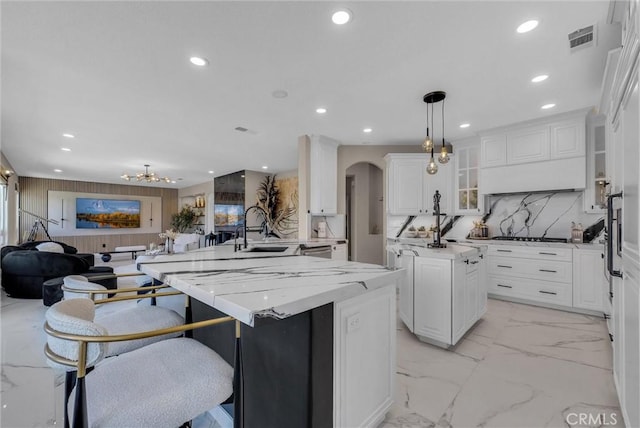 27055 Big Horn Mountain Way, Yorba Linda, CA 92887 - kitchen featuring a sink, light marble finish flooring, open floor plan, a center island with sink, and glass insert cabinets