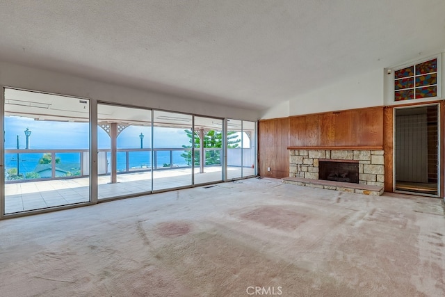1947 Palacios Dr, San Pedro, CA 90732 - unfurnished living room with wood walls, carpet floors, a fireplace, a textured ceiling, and a water view