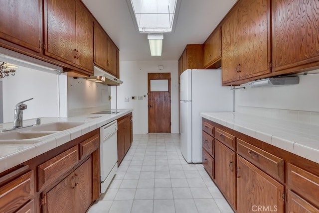 1947 Palacios Dr, San Pedro, CA 90732 - kitchen featuring a sink, white dishwasher, brown cabinetry, a skylight, and tile counters