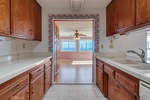 1947 Palacios Dr, San Pedro, CA 90732 - kitchen featuring a sink, brown cabinetry, ceiling fan, tile countertops, and light tile patterned floors