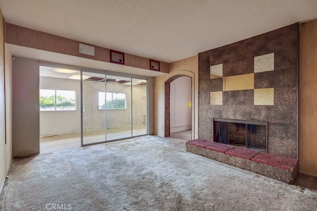 1947 Palacios Dr, San Pedro, CA 90732 - unfurnished living room featuring carpet floors, arched walkways, a large fireplace, and a textured ceiling
