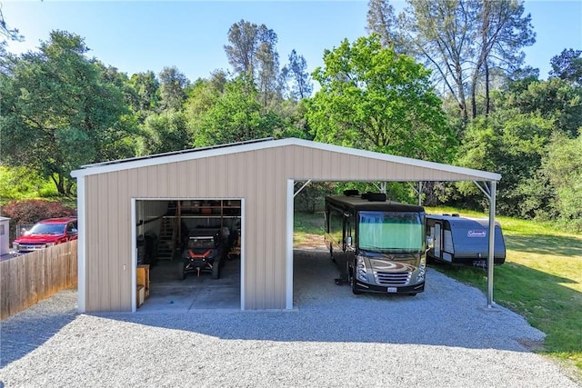 view of car parking with a detached garage and gravel driveway
