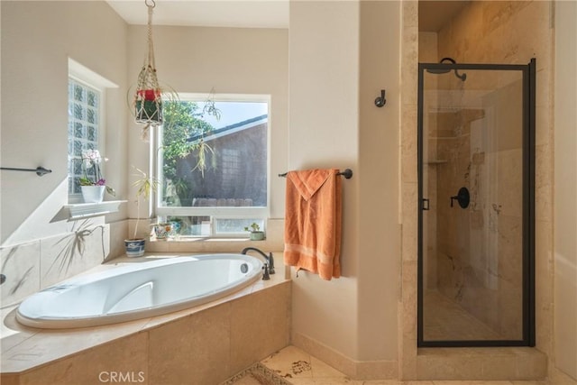 bathroom featuring a stall shower, a bath, and tile patterned flooring