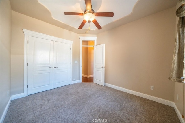 unfurnished bedroom featuring carpet, baseboards, and a tray ceiling