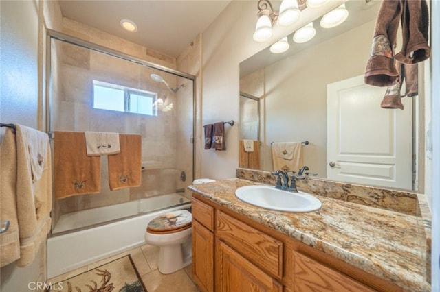 full bath with shower / bath combination with glass door, toilet, vanity, and tile patterned flooring