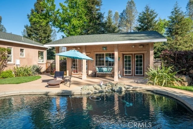 swimming pool with an exterior structure, an outdoor structure, a patio area, and fence