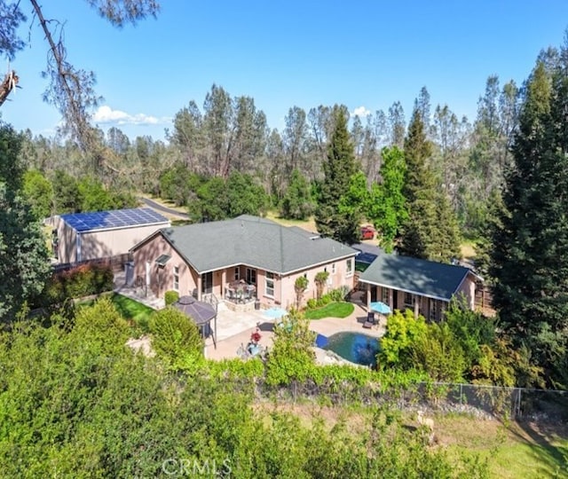 view of subject property featuring a pool and a forest