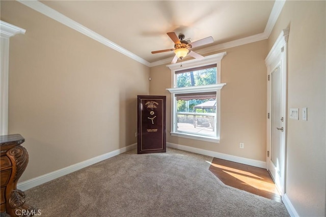 carpeted spare room with ceiling fan, crown molding, and baseboards