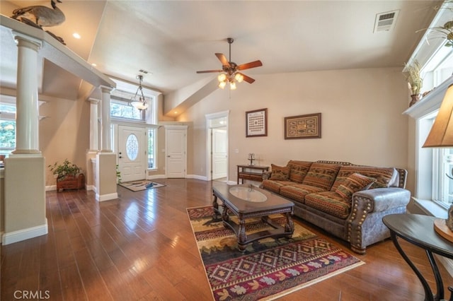 living area featuring ornate columns, ceiling fan, dark wood finished floors, baseboards, and lofted ceiling