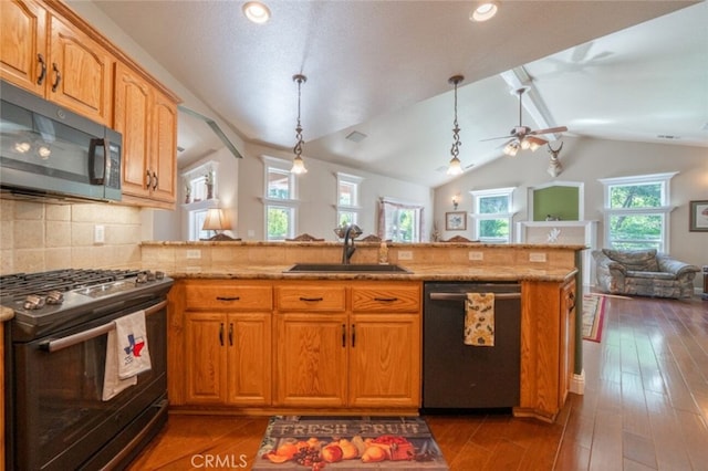 kitchen with gas stove, dishwasher, open floor plan, a sink, and vaulted ceiling