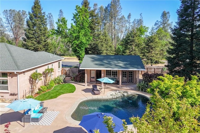 view of swimming pool featuring a storage structure, fence, an outbuilding, and a patio