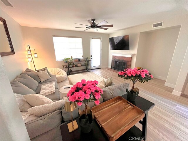 45723 Pheasant Pl, Temecula, CA 92592 - living area with a ceiling fan, a fireplace, light wood-style floors, and baseboards