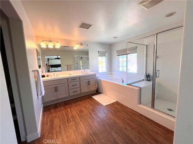45723 Pheasant Pl, Temecula, CA 92592 - bathroom featuring a bath, wood finished floors, double vanity, a stall shower, and a textured ceiling