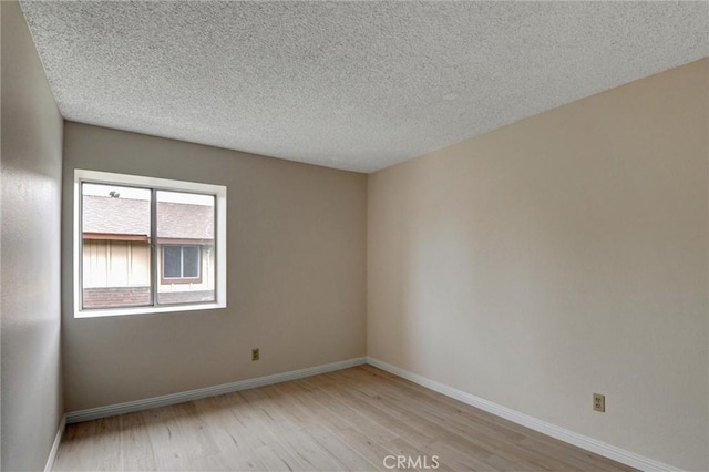 11000 Woodruff Ave Unit 14, Downey, CA 90241 - empty room with light wood-style floors, baseboards, and a textured ceiling