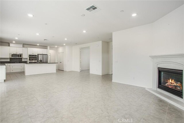 1004 Violet Ct, Calimesa, CA 92320 - unfurnished living room featuring recessed lighting and a glass covered fireplace