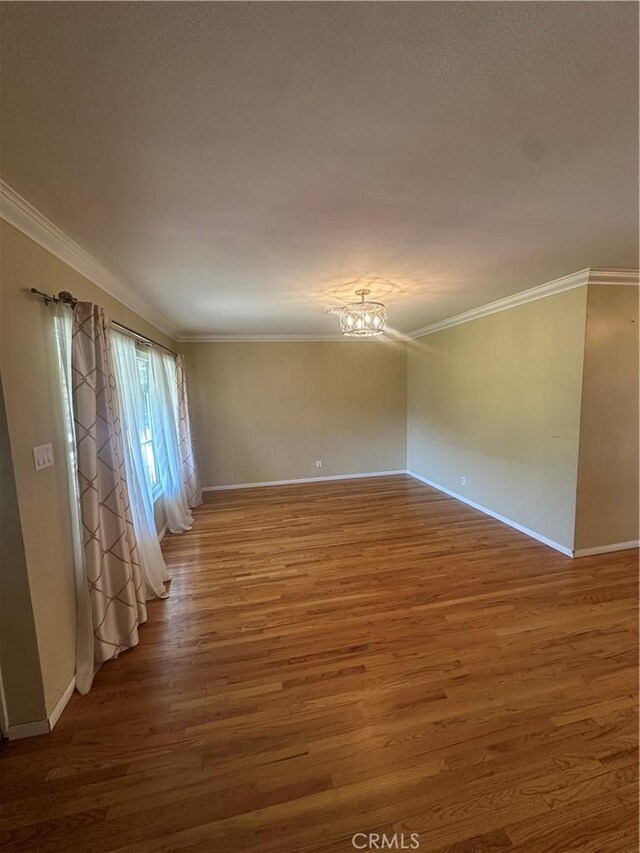 7918 Kyle St, Sunland, CA 91040 - spare room with baseboards, wood finished floors, a chandelier, and crown molding